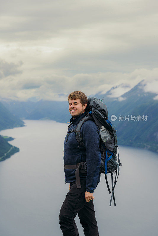 快乐的人背着背包在挪威的夏日山区徒步旅行