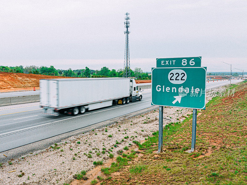 一辆白色“大钻机”半挂车高速通过标志进入美国肯塔基州格伦代尔市