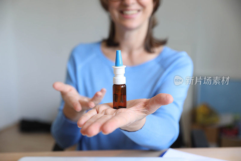 中年妇女手里拿着滴鼻药水