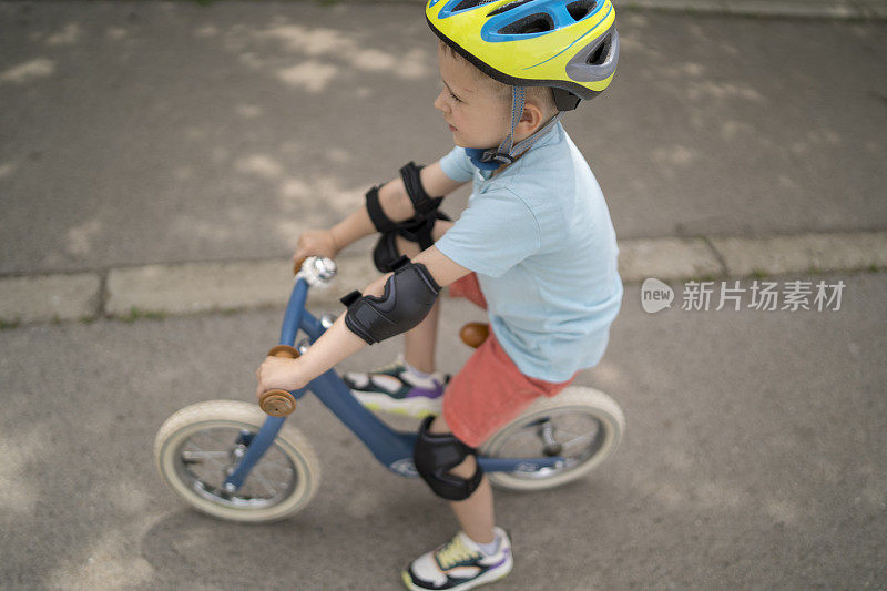 白人男孩在户外骑平衡自行车