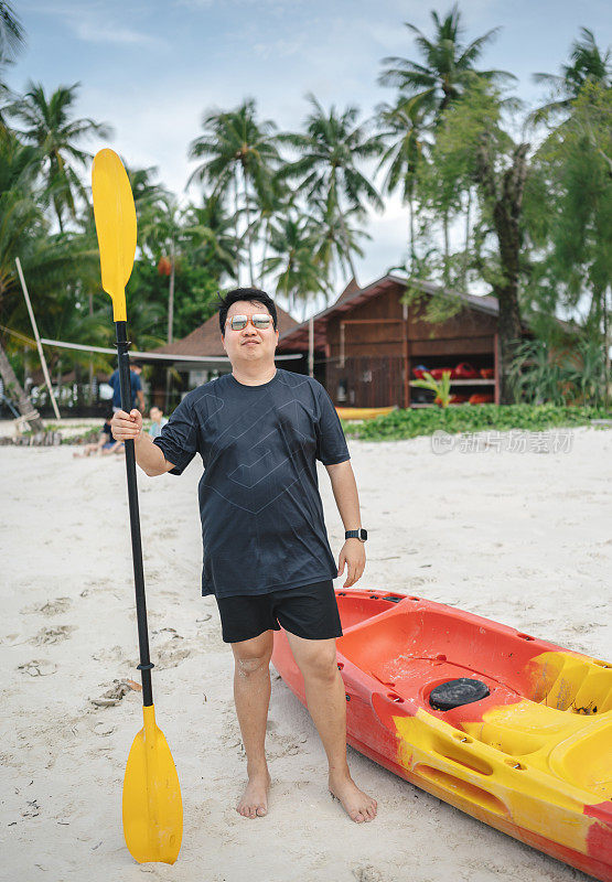 加码超重亚洲男子站在海滩虫准备皮艇在热带海滩