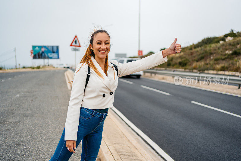 在马耳他的高速公路上搭便车的年轻女子