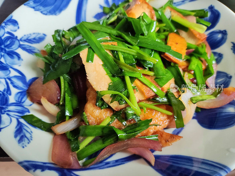 蓝色盘子里的干豆腐和韭菜炒