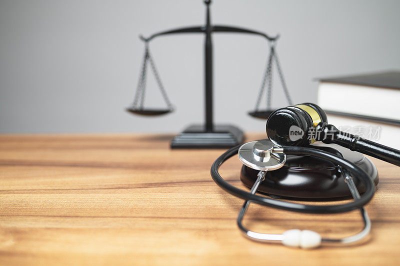 人身伤害法概念。法官室的中间有一个小木槌，听诊器放在桌子上是一个独特的概念，象征着法庭中正义和健康的交集。本空间