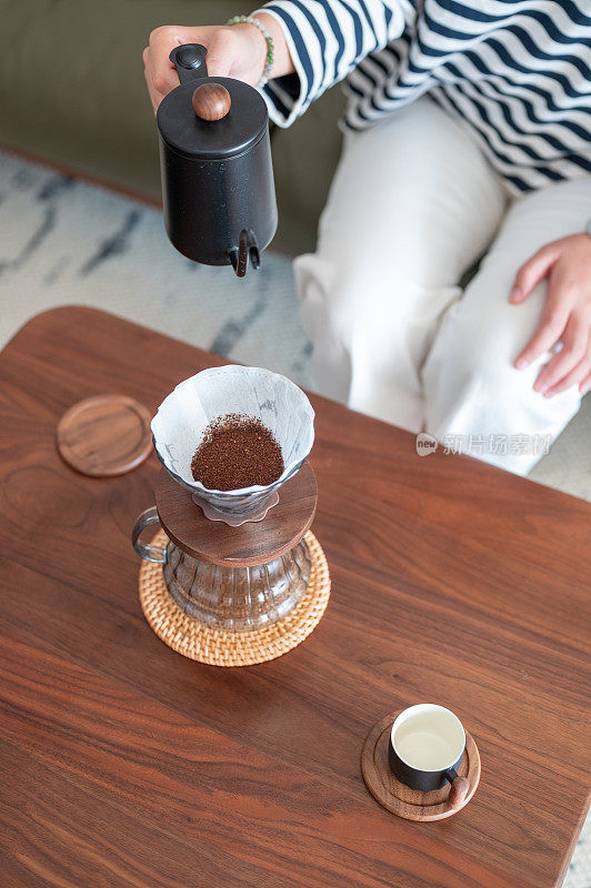 手滴咖啡师用过滤器将水倒在咖啡粉上