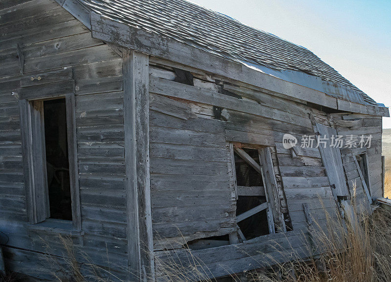 一座老旧的、废弃的、正在倒塌的木质建筑的外观