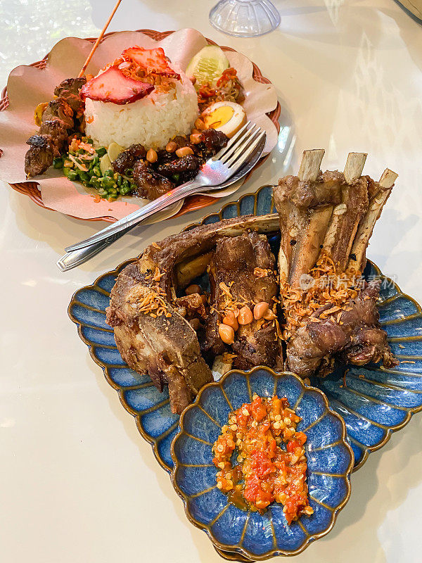 巴厘岛炸排骨是巴厘岛的印尼特色美食，包括蒸米饭、炒蔬菜、烤猪肉、脆猪皮、饼干、煮鸡蛋、内脏和沙茶。