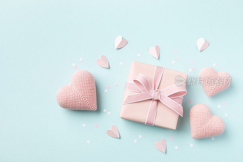生日，女人或母亲节贺卡。粉红色的心和礼盒上的蓝色粉彩桌面视图。平的。