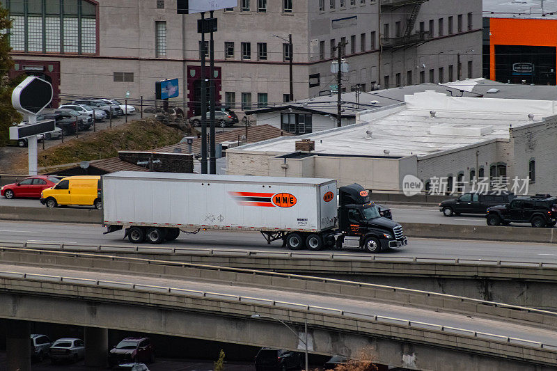 2021年10月——美国华盛顿州斯波坎。一辆中西部汽车快车(MME)半卡车行驶在华盛顿斯波坎市中心的90号州际公路上。MME是一家载货不足一卡车的货运公司。