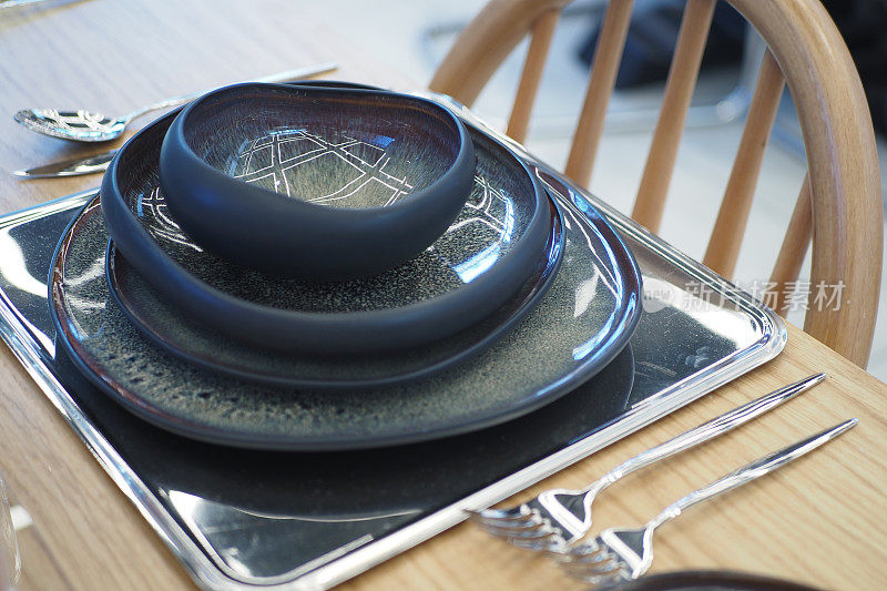 圆碗或陶瓷盘放在木制餐桌上的餐巾上。