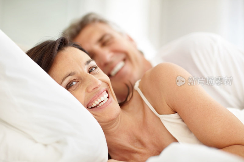 幸福的成熟夫妇躺在床上微笑