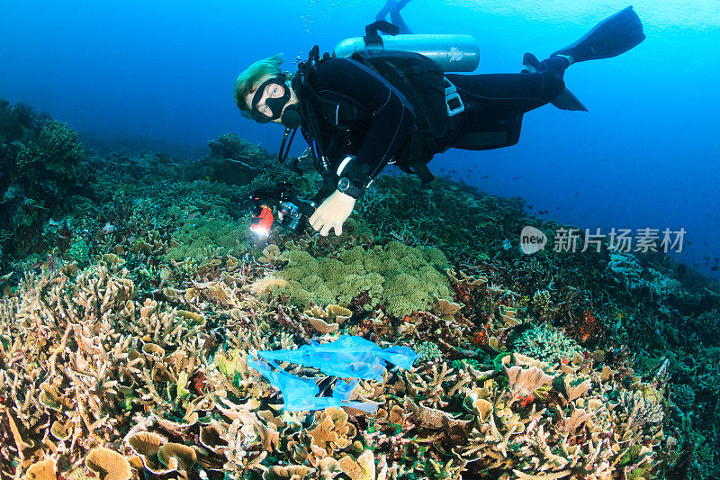 潜水员和塑料袋在珊瑚礁上