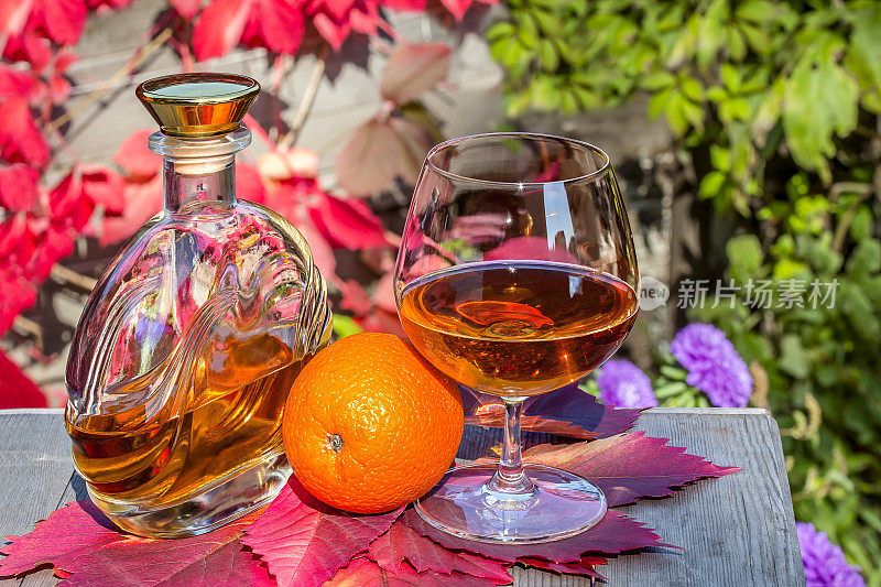 花园里的桌上有酒瓶和白兰地和橘子