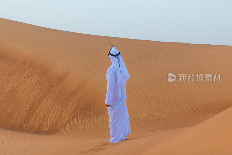 一个阿拉伯人在迪拜的沙漠中指明方向