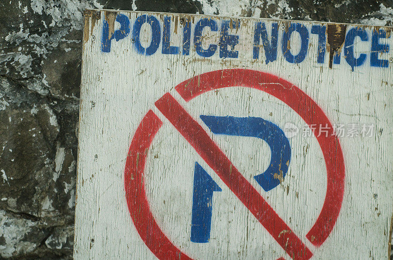 “禁止停车”的警示牌贴在旧墙上