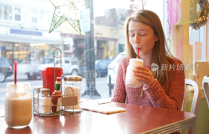 十几岁的女孩喝着奶昔