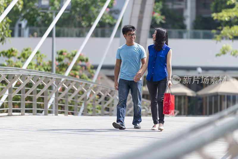 快乐的年轻亚洲夫妇在桥上滚动