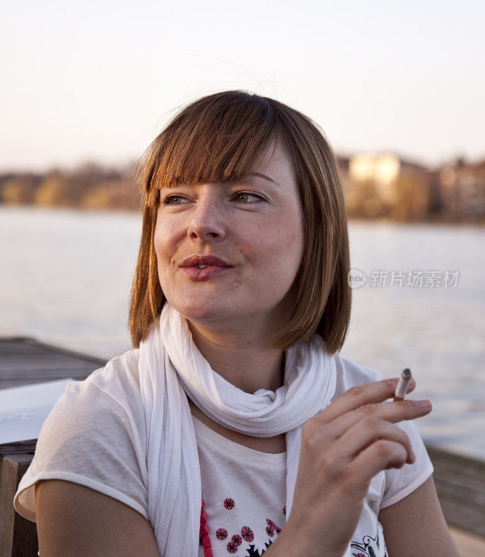 在湖边的画像上抽烟的女人