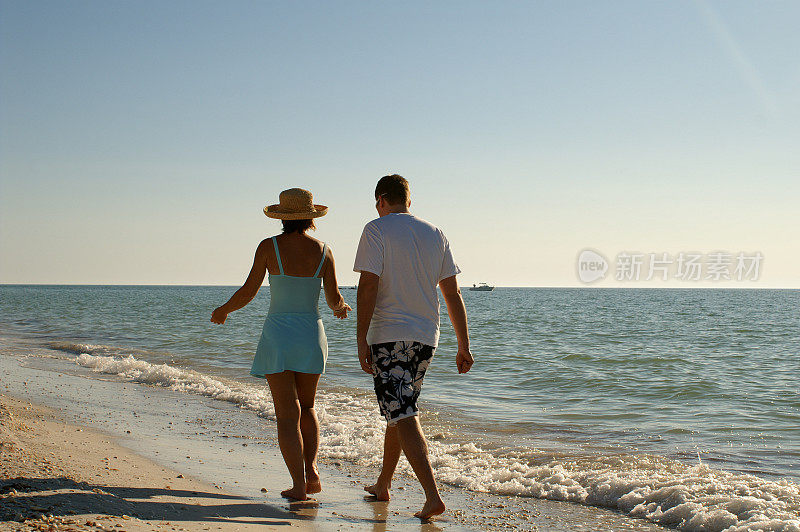 沙滩情侣在沙滩上散步
