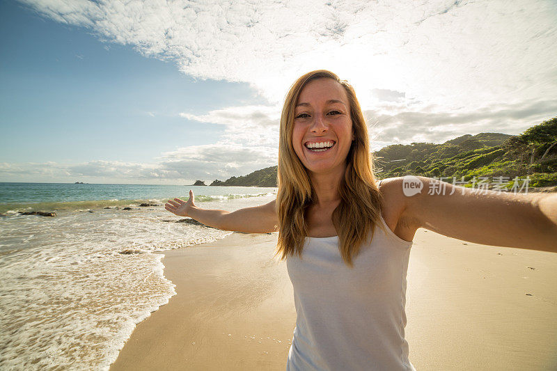 一名白人年轻女子在海滩上自拍
