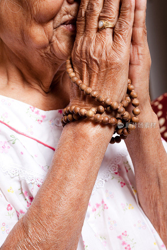 年长精神妇女祈祷双手皱