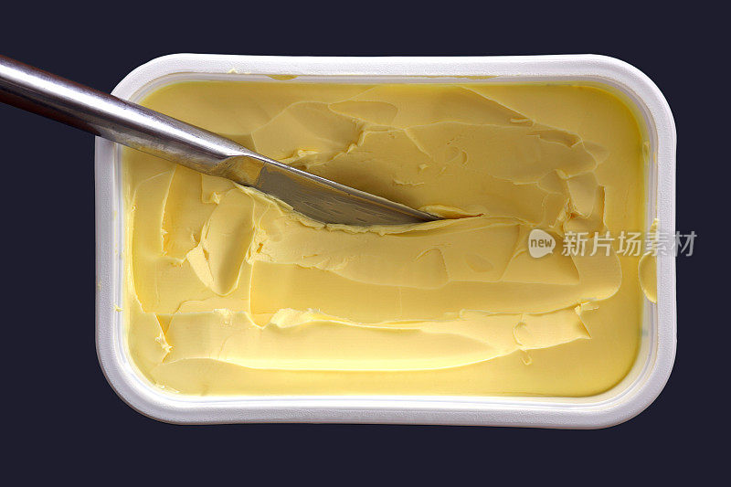杯中有刀的黄油，孤立的俯视图