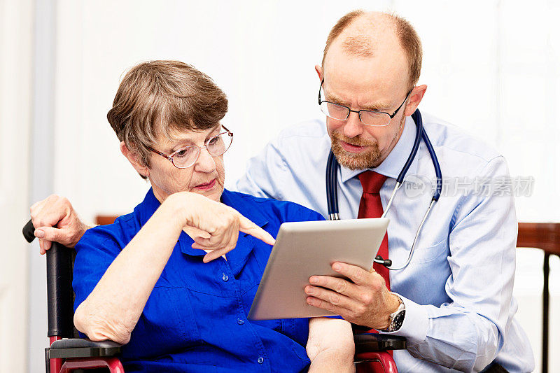 医生用平板电脑向老年病人解释健康问题