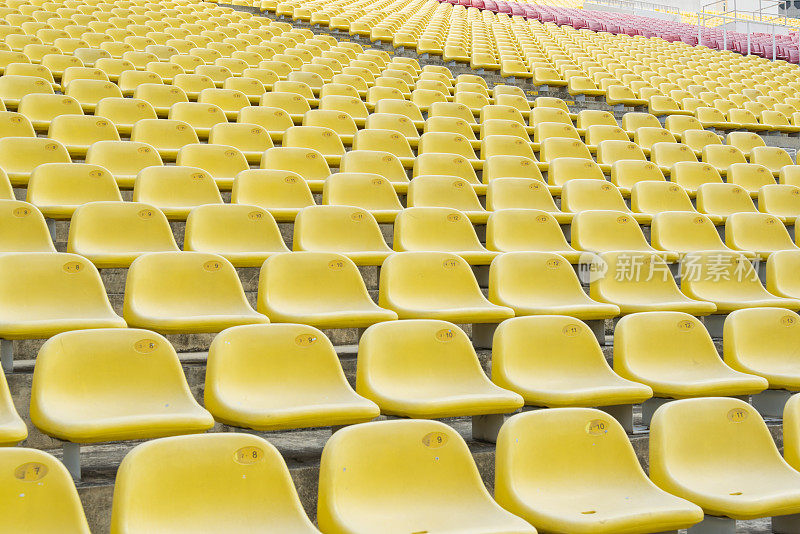 空旷的黄色塑料体育场座位。