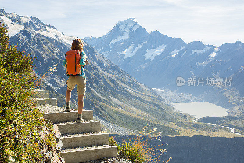 一个徒步旅行者站在山顶欣赏风景