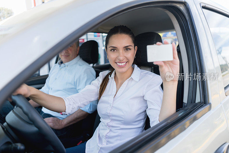 一个女人在加油站开车，手里拿着会员卡