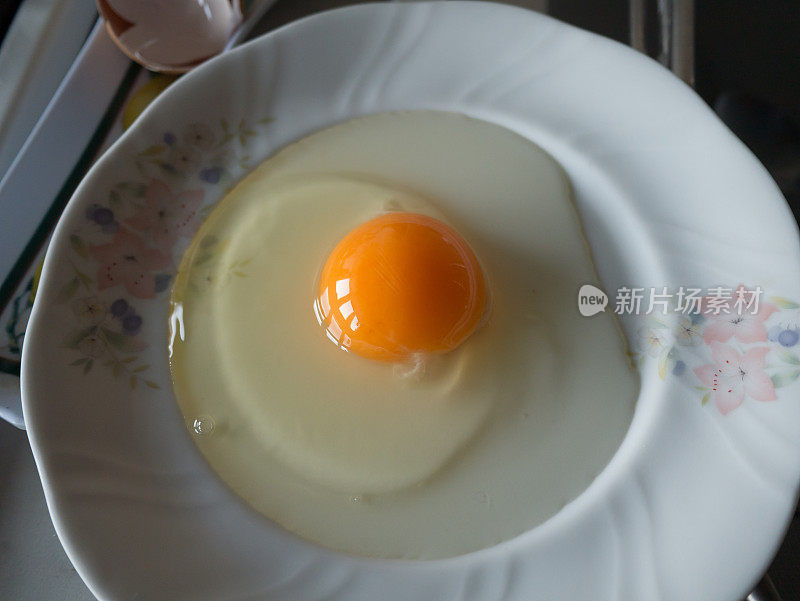 把鸡蛋打开放在盘子里，打碎蛋壳