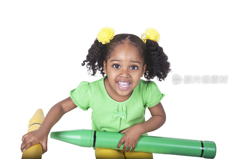 一个四岁的黑色学前班女孩拿着两个玩具蜡笔