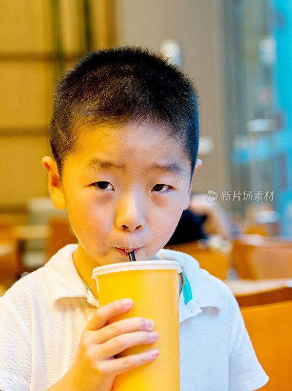小男孩用吸管喝果汁