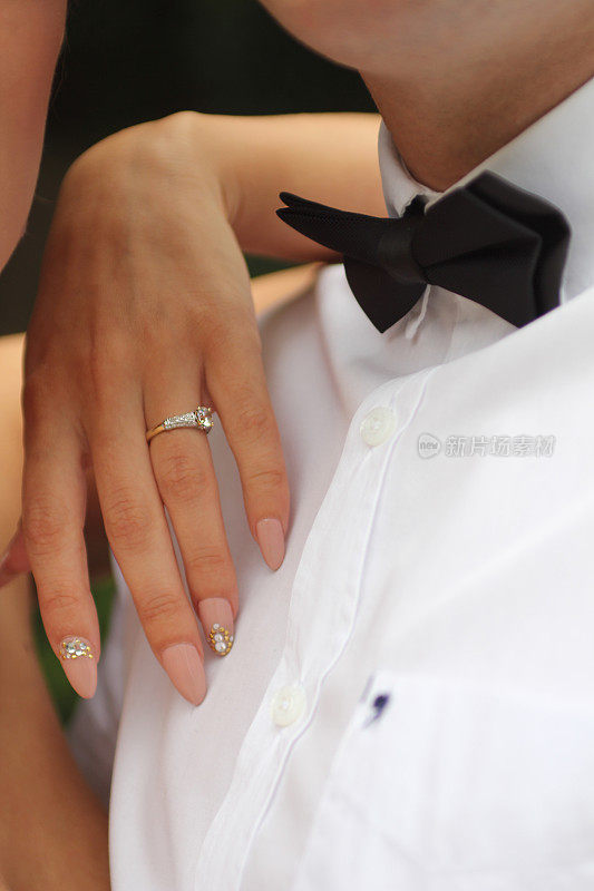 新婚夫妇展示戒指和领结