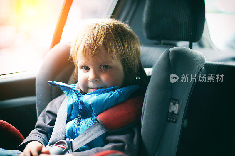可爱的小男孩在他的汽车座位上微笑