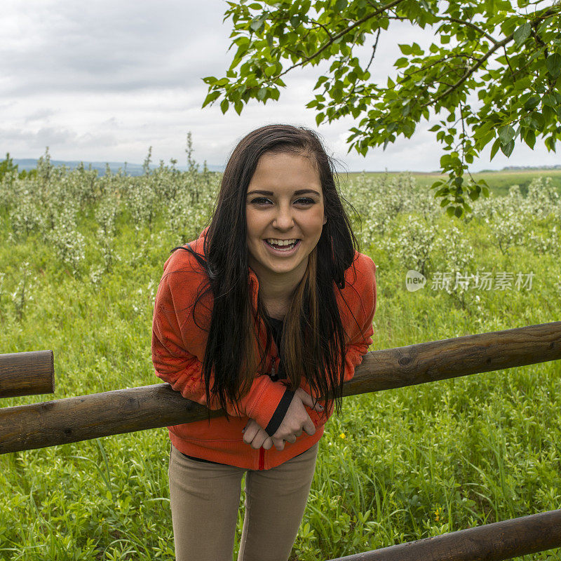 十几岁的女孩靠在篱笆上笑，农村的环境
