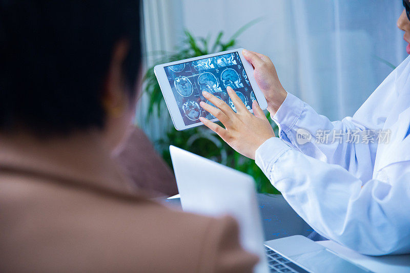 医生和病人在平板电脑上讨论x光