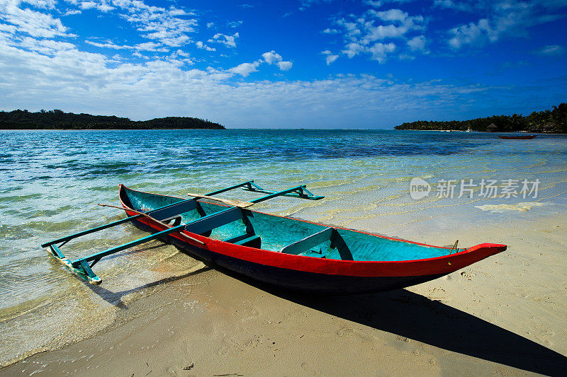 阳光下沙滩上的空独木舟