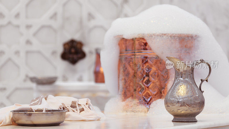 水罐，毛巾和带肥皂泡沫的土耳其哈曼铜碗。传统的内部细节