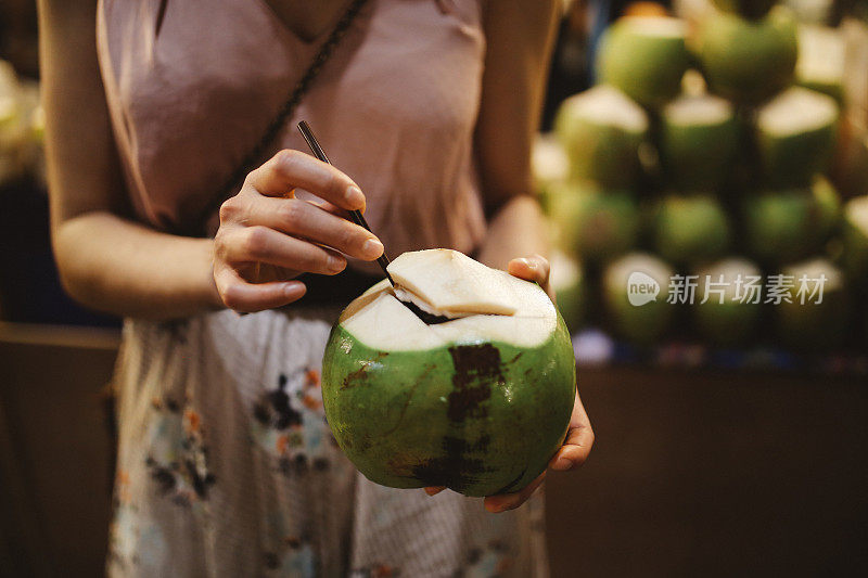 泰国街头小吃-年轻女子有一个美味和新鲜的椰子汁在路上