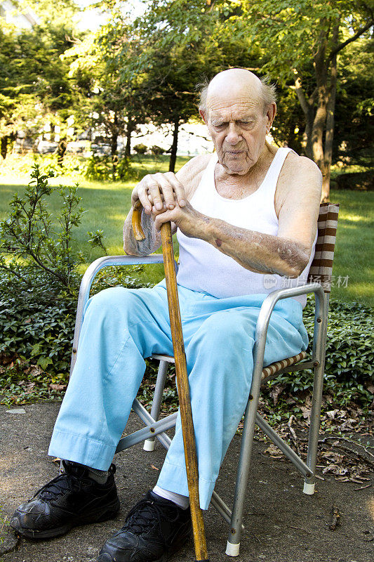 拄着拐杖坐在后院的老人，对生活充满了疑惑。