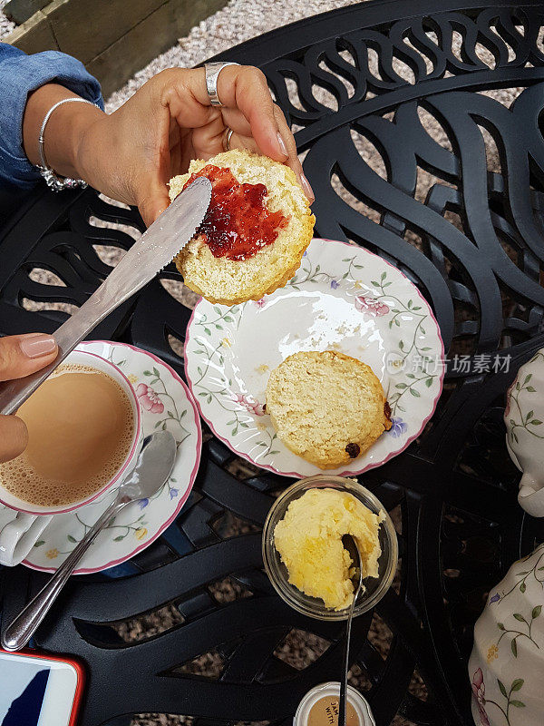 典型的德文郡奶茶，包括烤饼，黄油，德文郡奶油，果酱和英国茶。