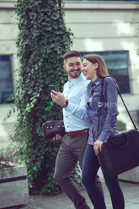 微笑的商业夫妇走在街上聊天