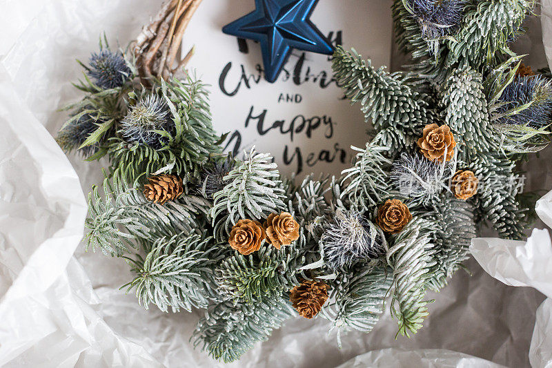 呈现、生活方式、盛宴理念。用云杉树枝编成圣诞花环，装饰着迷人的小松果和蓝星，玻璃玩具为圣诞树