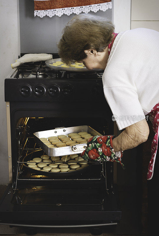 女人正在把法式烤面包放进烤箱烤。