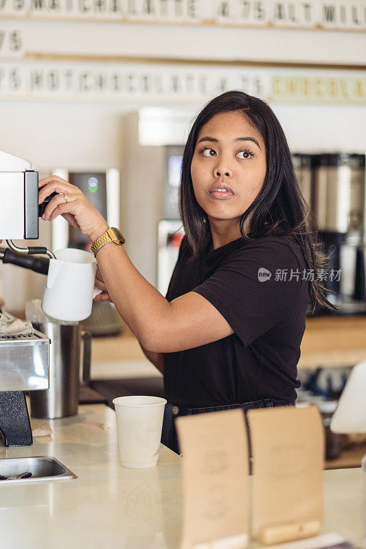 年轻的女咖啡师正在煮咖啡