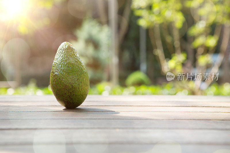 公园里的木桌上放牛油果。水果和蔬菜概念。