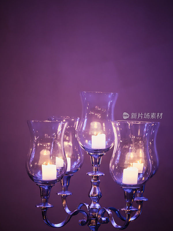 紫色穆迪神秘发光的蜡烛烛台，黑暗的背景