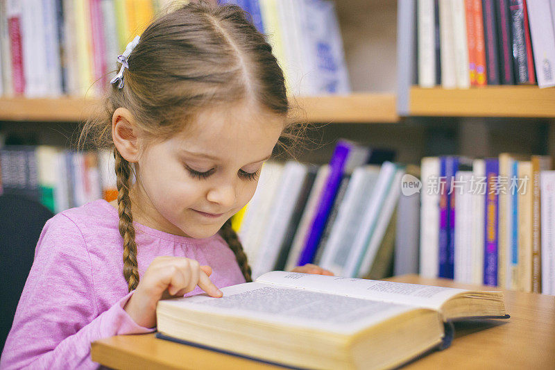 一个小女孩在图书馆看书