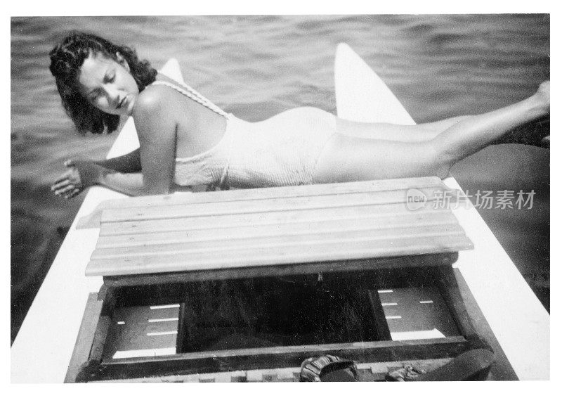 1939年，一名穿着泳装的年轻女子在一条小船上